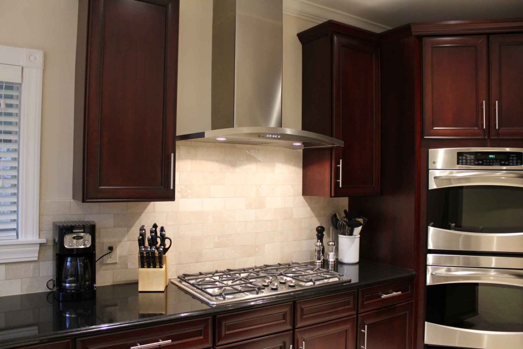 New kitchen cabinets installed surrounding gas stove and wall oven